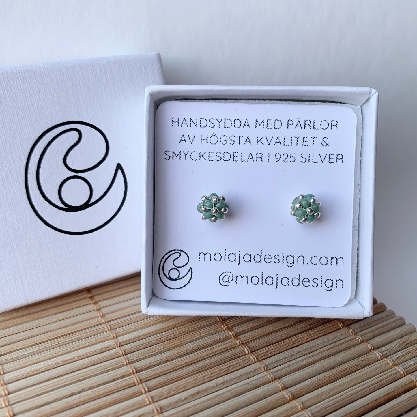Turkosgrön studs i smyckesask med text från MoLaja Design.