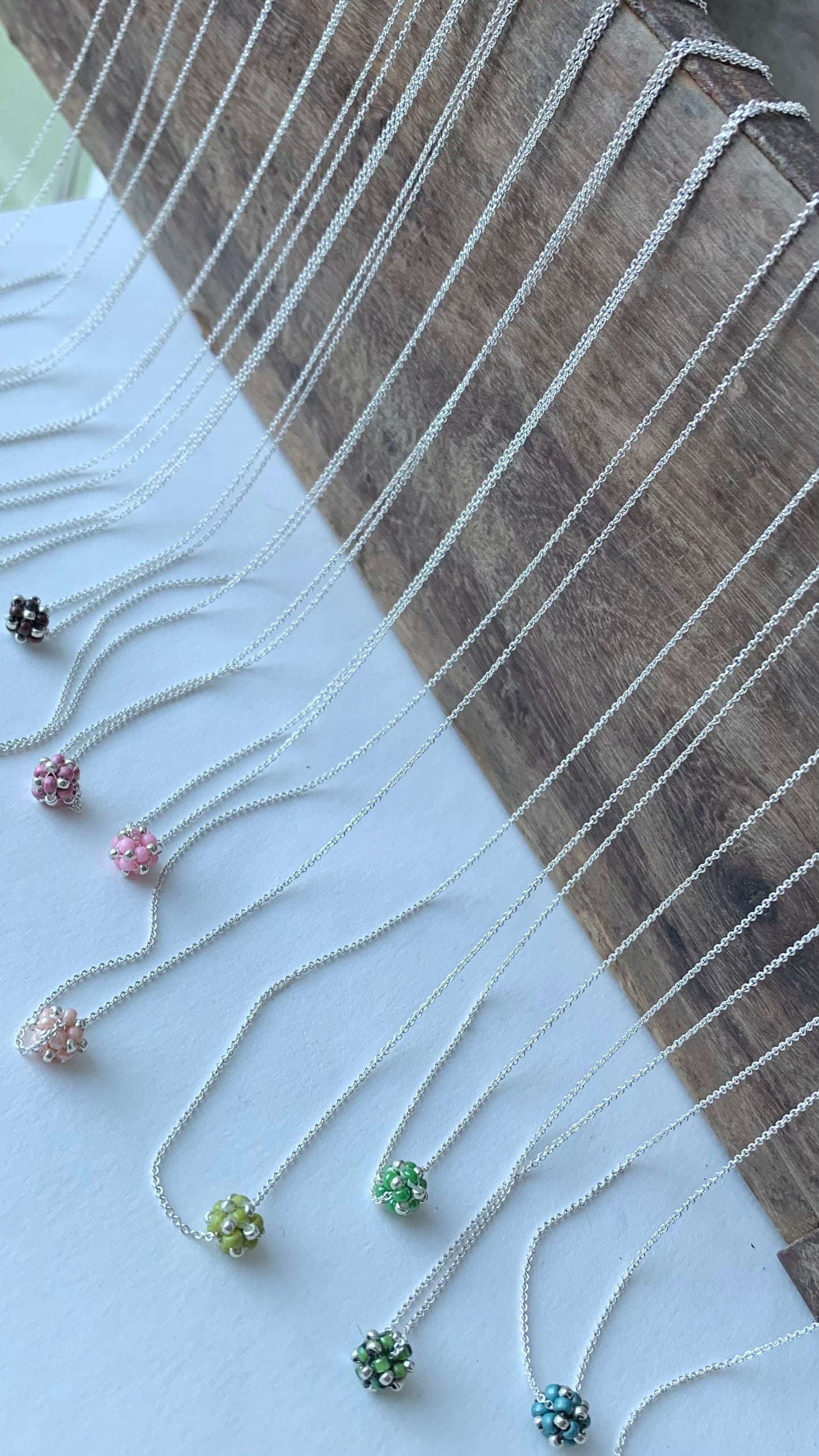 Halskedjor i silver med små pärlade pärlor i rosa och grönt
