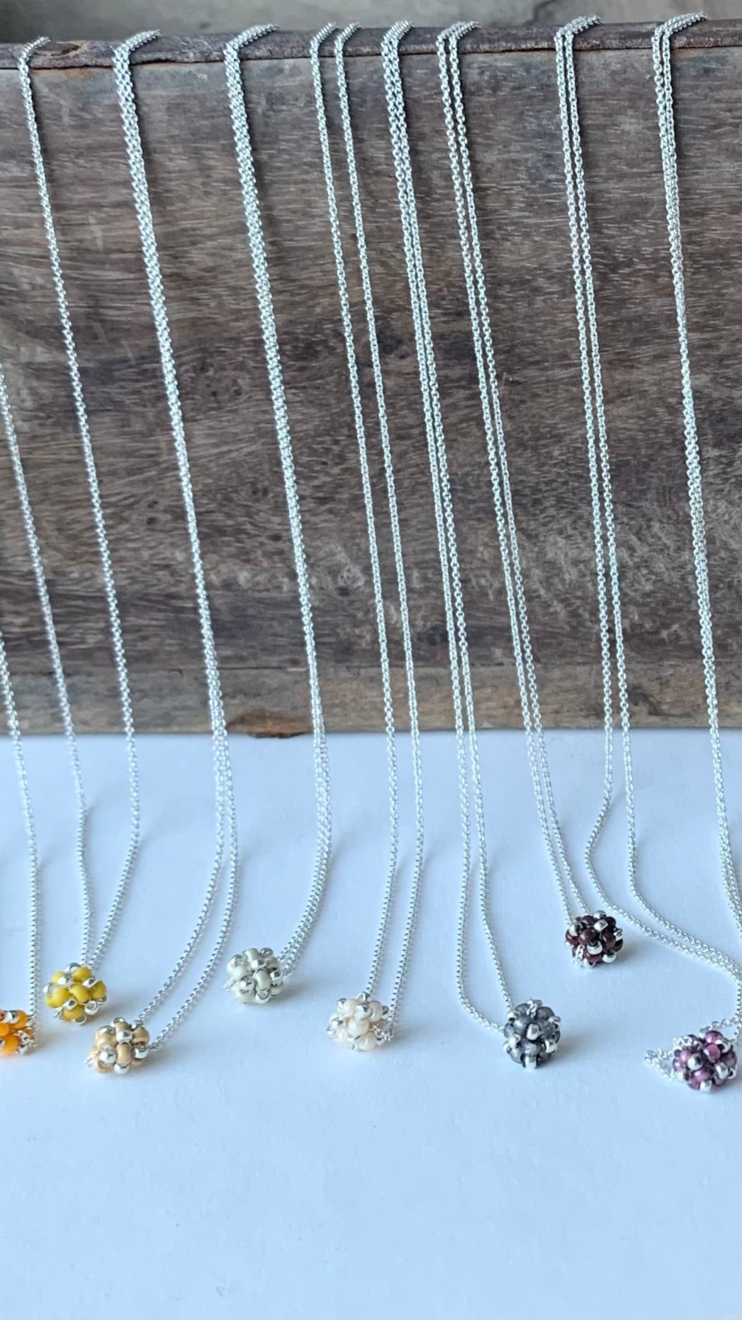 Halskedjor i silver med små pärlade pärlor i gult, silver och grått