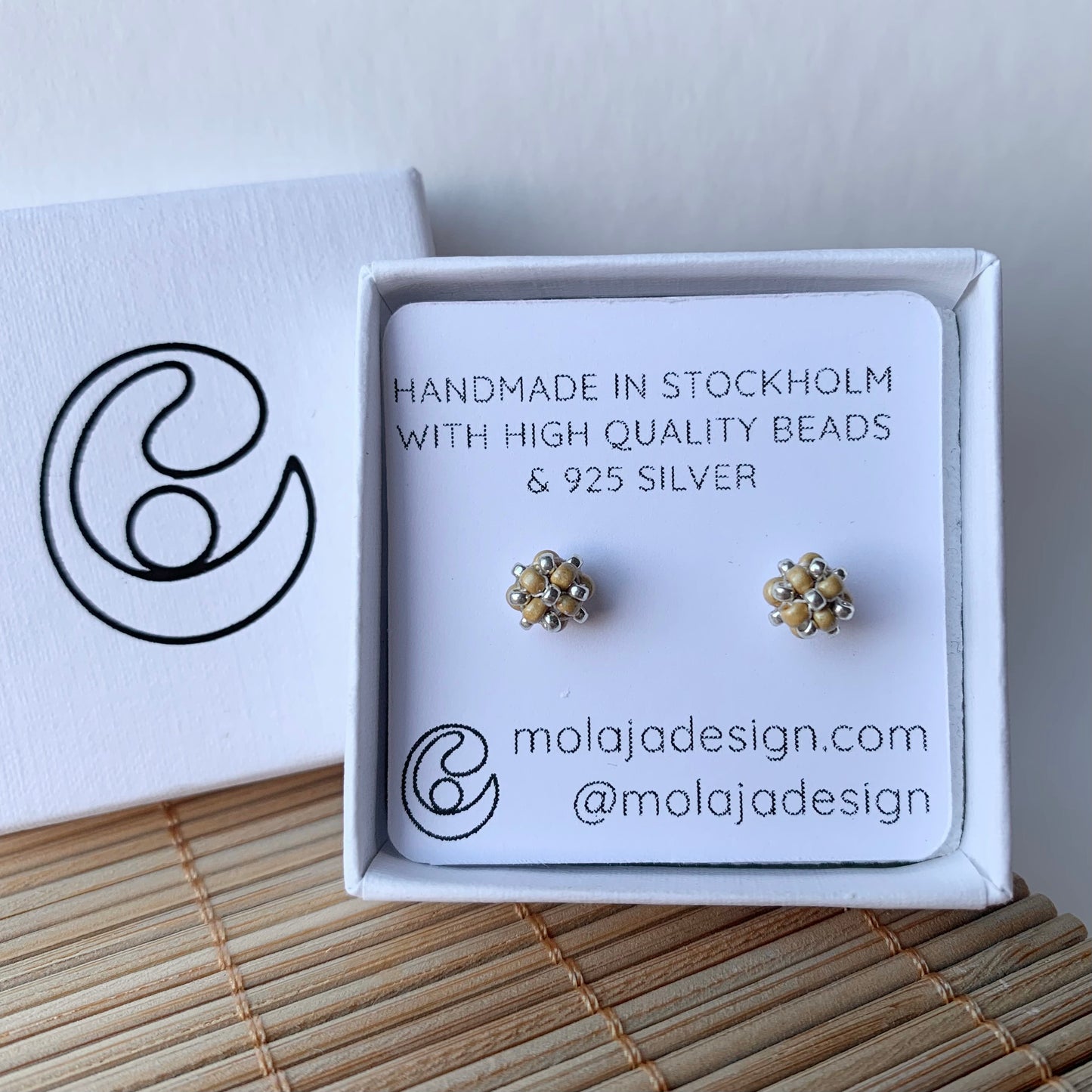 Matt guld studs i smyckesask med text från MoLaja Design.