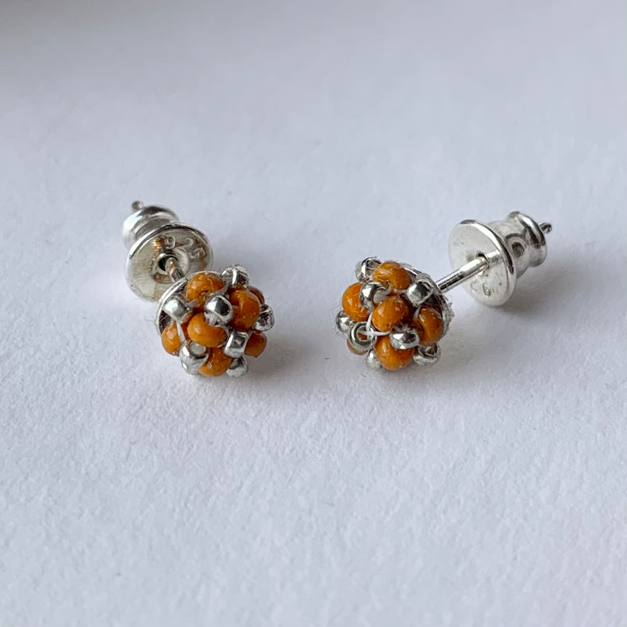 Örhängen stift med liten pärlad pärla i mandarin och silver från MoLaja Design